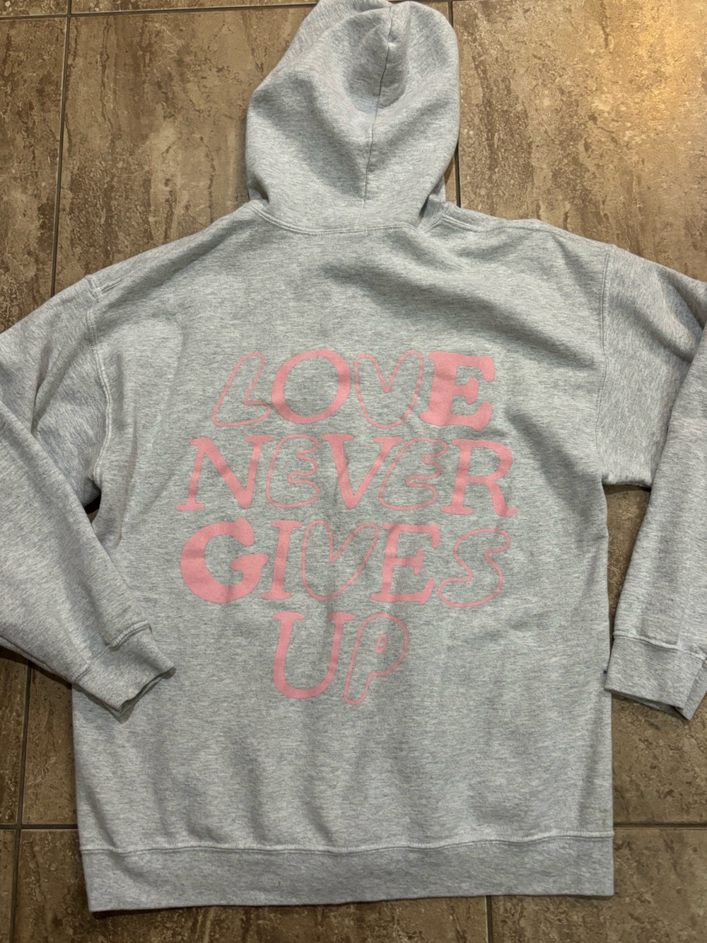 Motivational “Love never gives up” graphic zip up Christian hoodie